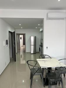 a dining room with a table and chairs and a refrigerator at Tarrafal Apartments in Tarrafal