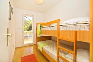 a bedroom with two bunk beds and a door at Seaside secluded apartments Cove Tvrdni Dolac, Hvar - 4008 in Gdinj