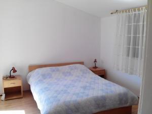 a bedroom with a bed with a blue comforter at Apartments by the sea Sepurine, Prvic - 4238 in Prvić Šepurine