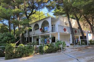 ein weißes Haus mit Bäumen davor in der Unterkunft Apartments by the sea Balica Rat, Omis - 1065 in Omiš