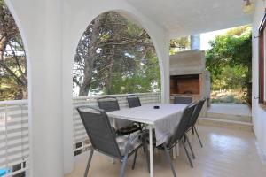 a table and chairs on a porch with a fireplace at Apartments by the sea Balica Rat, Omis - 1065 in Omiš