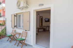 a patio with two chairs and a table and a window at Le Quartier Comfy Studios in Parga