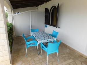 a table and blue chairs in a patio at Apartments by the sea Slatine, Ciovo - 1128 in Slatine +30 photos