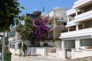 um edifício com flores roxas ao lado em Apartments by the sea Molunat, Dubrovnik - 2137 em Molunat