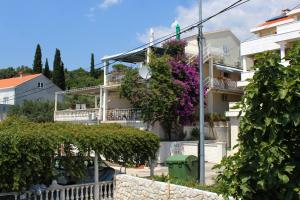 um edifício com flores ao lado em Apartments by the sea Molunat, Dubrovnik - 2137 em Molunat