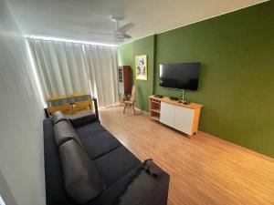 a living room with a couch and a flat screen tv at Apto novo em Icarai in Niterói
