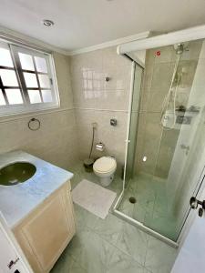 a bathroom with a shower and a sink and a toilet at Apto novo em Icarai in Niterói