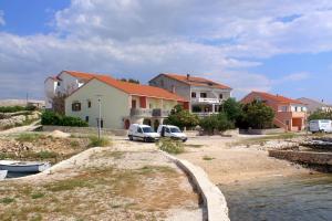 a group of houses and cars parked next to a river at Apartments by the sea Kustici, Pag - 4081 in Zubovići