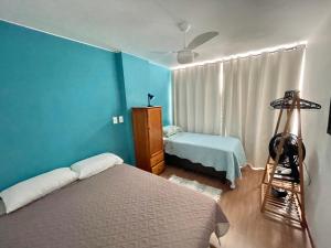a bedroom with two beds and a blue wall at Apto novo em Icarai in Niterói