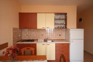 a kitchen with a white refrigerator and wooden cabinets at Apartments by the sea Kustici, Pag - 4081 in Zubovići
