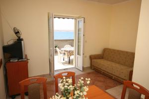 a living room with a couch and a table at Apartments by the sea Kustici, Pag - 4081 in Zubovići