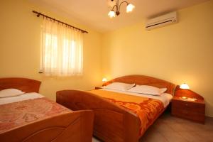 a bedroom with two beds and a window at Apartments by the sea Kustici, Pag - 4081 in Zubovići
