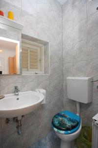 a bathroom with a toilet and a sink at Apartments and rooms by the sea Supetarska Draga - Donja, Rab - 2001 in Rab