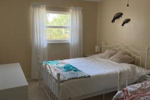 um quarto com uma cama branca e uma janela em Heated Pool Paradise, Gulf Access, Pet Friendly em Port Charlotte