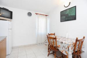 a kitchen and dining room with a table and chairs at Apartments with a parking space Slatine, Ciovo - 2030 in Trogir