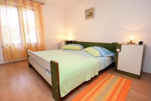 a bedroom with a large bed with two pillows at Apartments by the sea Slatine, Ciovo - 2039 in Slatine