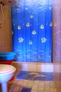a shower with a blue shower curtain with fish on it at Seaside holiday house Cove Zarace - Gdinj, Hvar - 2048 in Gdinj