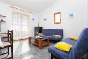 a living room with a blue couch and a table at Apartments by the sea Sevid, Trogir - 2044 in Sevid