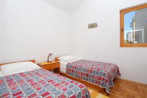 a bedroom with two beds and a window at Apartments by the sea Sevid, Trogir - 2044 in Sevid