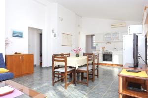a kitchen and dining room with a table and chairs at Apartments by the sea Sevid, Trogir - 2044 in Sevid