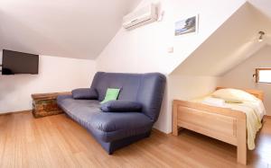 Una sala de estar con un sofá azul y una cama. en Apartments by the sea Zavala, Hvar - 2061, en Zavala