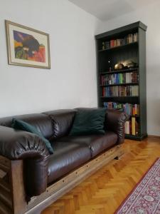 un sofá de cuero en una sala de estar con estantería. en Apartments with a parking space Trogir - 2046 en Trogir
