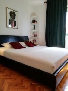 1 cama grande con sábanas blancas y almohadas rojas en Apartments with a parking space Trogir - 2046 en Trogir