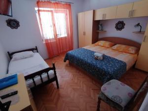 sypialnia z 2 łóżkami, biurkiem i oknem w obiekcie Apartments with a parking space Jelsa, Hvar - 2059 w mieście Jelsa