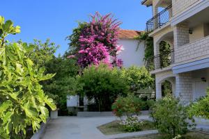 ein Gebäude mit einem Baum mit rosa Blumen drauf in der Unterkunft Apartments by the sea Okrug Gornji, Ciovo - 1069 in Trogir