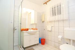ein weißes Badezimmer mit Waschbecken und Dusche in der Unterkunft Apartments by the sea Okrug Gornji, Ciovo - 1069 in Trogir