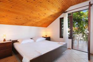 ein Schlafzimmer mit einem großen Bett und einer Holzdecke in der Unterkunft Apartments by the sea Okrug Gornji, Ciovo - 1069 in Trogir