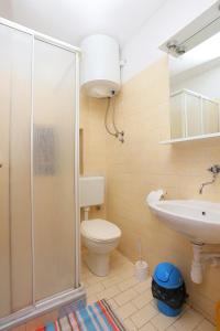 ein Badezimmer mit Dusche, Toilette und Waschbecken in der Unterkunft Apartments by the sea Okrug Gornji, Ciovo - 1069 in Trogir + 28 Fotos