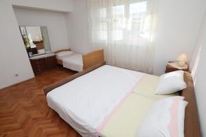 sypialnia z dużym białym łóżkiem i lustrem w obiekcie Apartment Vinisce 1165b w mieście Vinišće