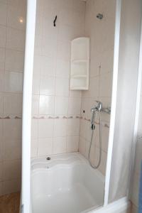 łazienka z prysznicem i białą wanną w obiekcie Apartment Vinisce 1165b w mieście Vinišće
