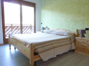 una camera con un letto e una grande finestra di Appartamento finestra sul parco a Comano Terme
