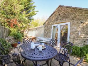 a blue table and chairs on a patio at Mimosa Cottage in Swyre