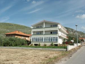 a large white house with a hill in the background at Apartments by the sea Seget Donji, Trogir - 2041 in Trogir