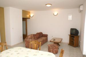 a living room with a couch and a tv at Apartments by the sea Seget Donji, Trogir - 2041 in Trogir