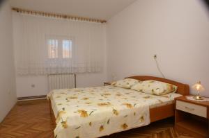 Schlafzimmer mit einem Bett und einem Fenster in der Unterkunft Apartments by the sea Seget Donji, Trogir - 2041 in Trogir