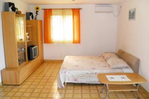 a small bedroom with a bed and a table at Apartments by the sea Cove Ljubljeva, Trogir - 2194 in Voluja