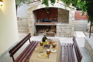 a table with plates of food in front of a fireplace at Apartments by the sea Cove Ljubljeva, Trogir - 2194 in Voluja