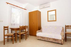a living room with a bed and a table and chairs at Apartments by the sea Zaton Veliki, Dubrovnik - 2107 in Zaton