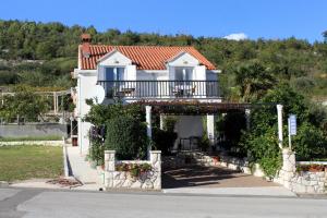 a house with a balcony and a porch at Apartments and rooms with parking space Slano, Dubrovnik - 2159 in Slano