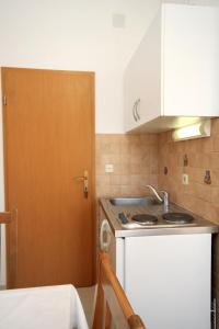 a small kitchen with a sink and a door at Apartments and rooms with parking space Slano, Dubrovnik - 2159 in Slano