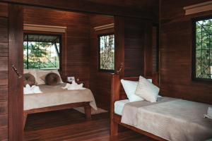 two beds in a room with wooden walls at Cabañas Don Ramiro in Colonia Dos Ríos