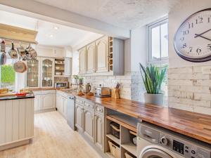 una cocina con un reloj grande en la pared en Bryn Rhosyn, en Pwllheli