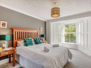 a bedroom with a large bed and a window at Bryn Rhosyn in Pwllheli