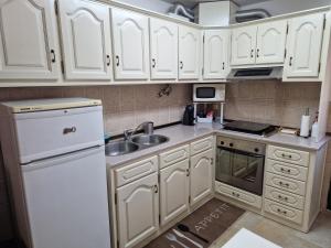 una cucina con armadietti bianchi e frigorifero bianco di T1 Centro Montargil a Montargil
