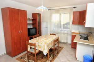 a kitchen with a table and a kitchen with a table and chairs at Apartments with a parking space Peroj, Fazana - 2234 in Peroj