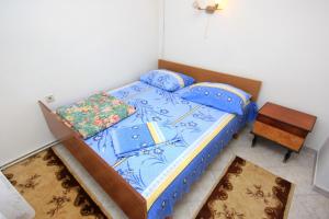 a bedroom with a bed with blue sheets and a table at Apartments with a parking space Peroj, Fazana - 2234 in Peroj